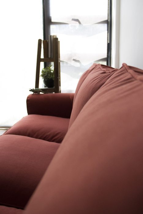 A view of the back cushions of an Ektorp sofa, covered in woollen rust-red slipcovers made by Comfort Works