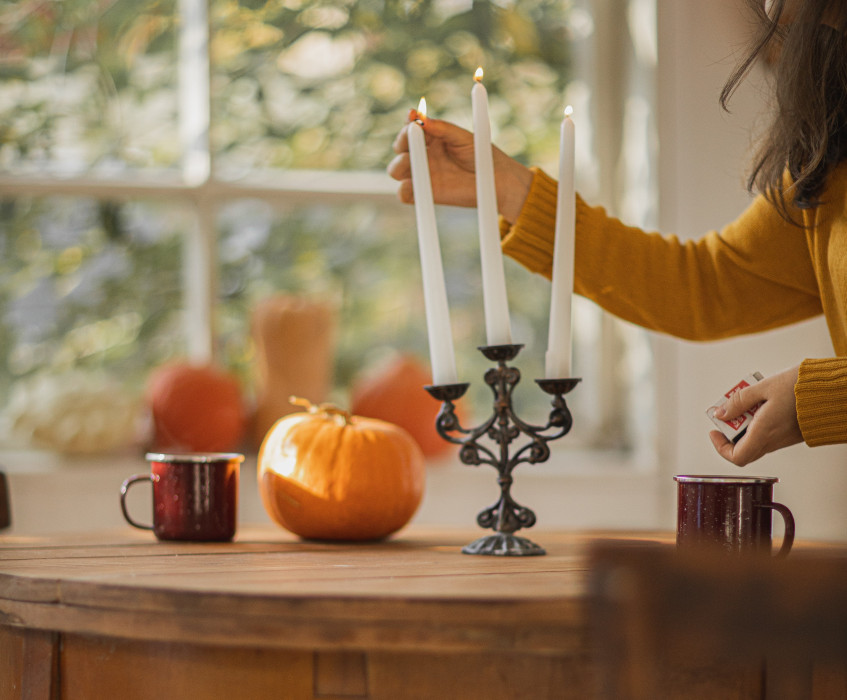 Woman decorating her home with fall candles and decoration