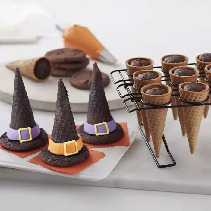 Halloween-Leckerei aus Eistüten und Zuckerguss, die wie Hexenhüte aussehen