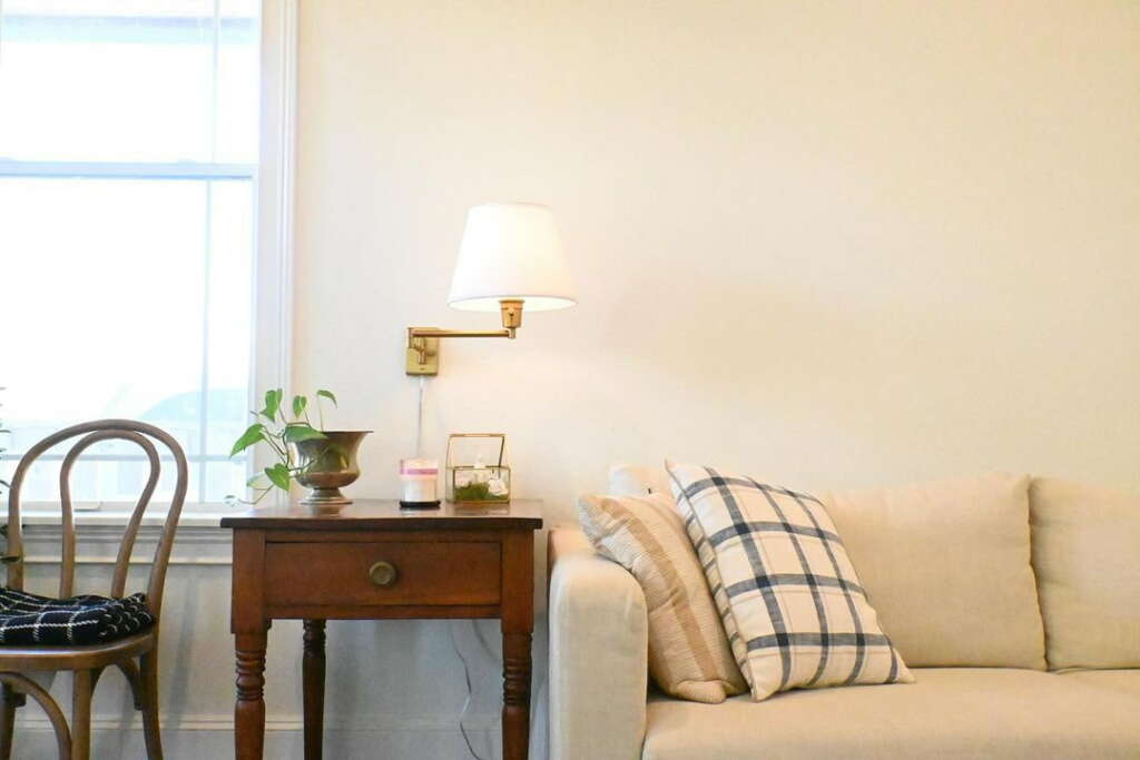 A beige sofa next to a wooden side table.