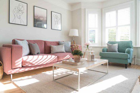 A pink and green couch in a living room.