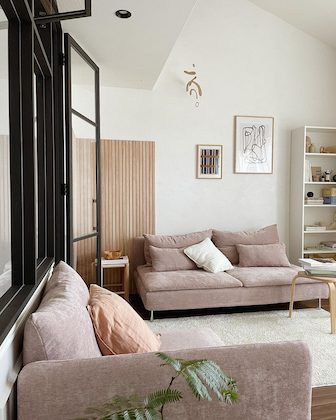 A dusty pink armchair and sofa in a living room.