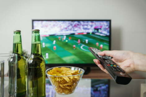 Chips and sofa on a coffee table in front of the television.