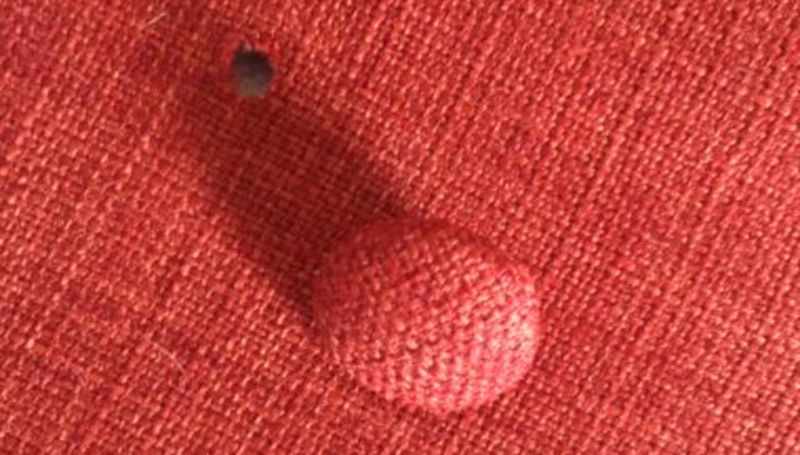 button-popping-off-red-fabric